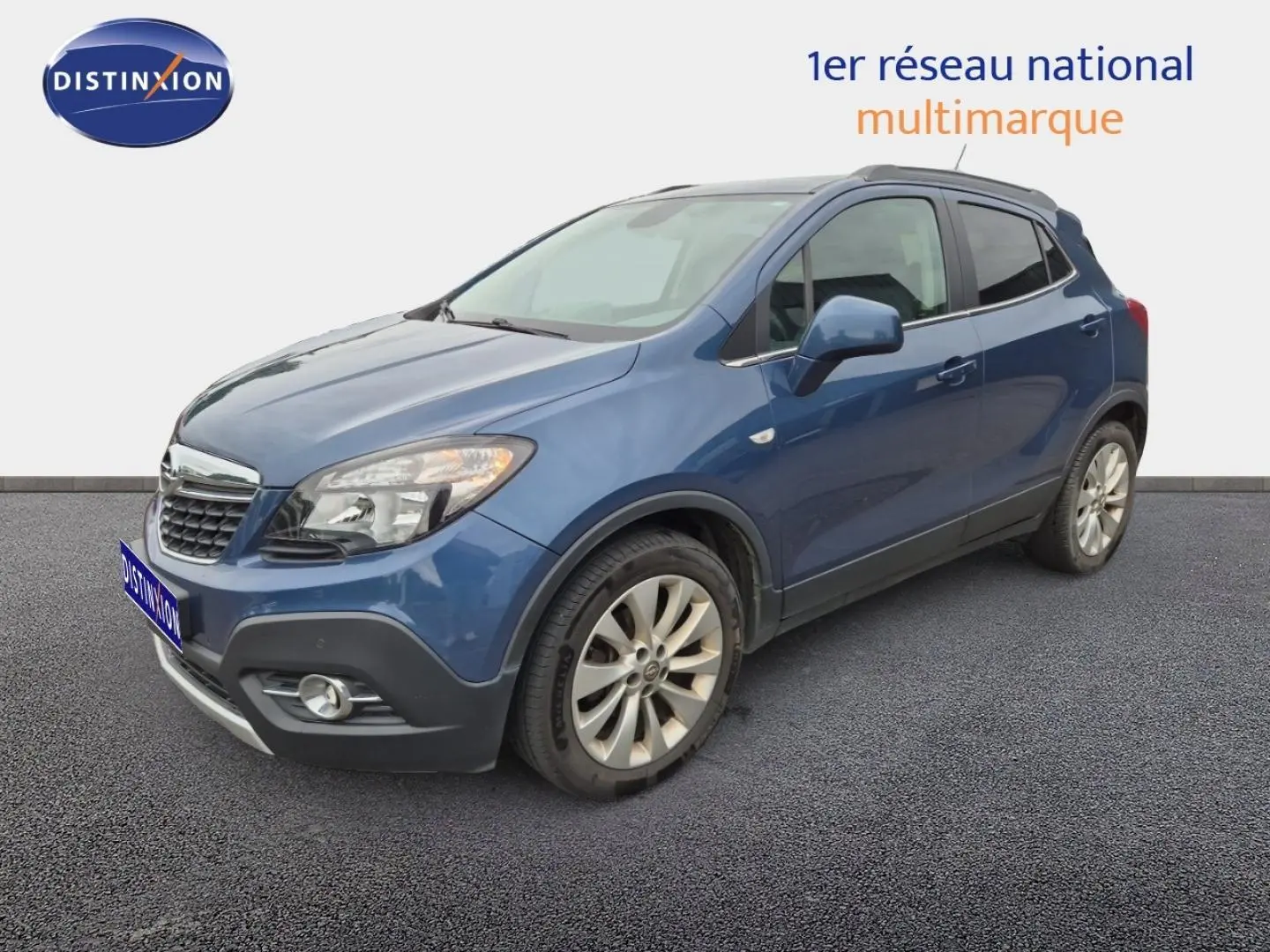 Opel Mokka bleu outremer en 3/4 avant droit, avec jantes alu et calandre chromée visible.