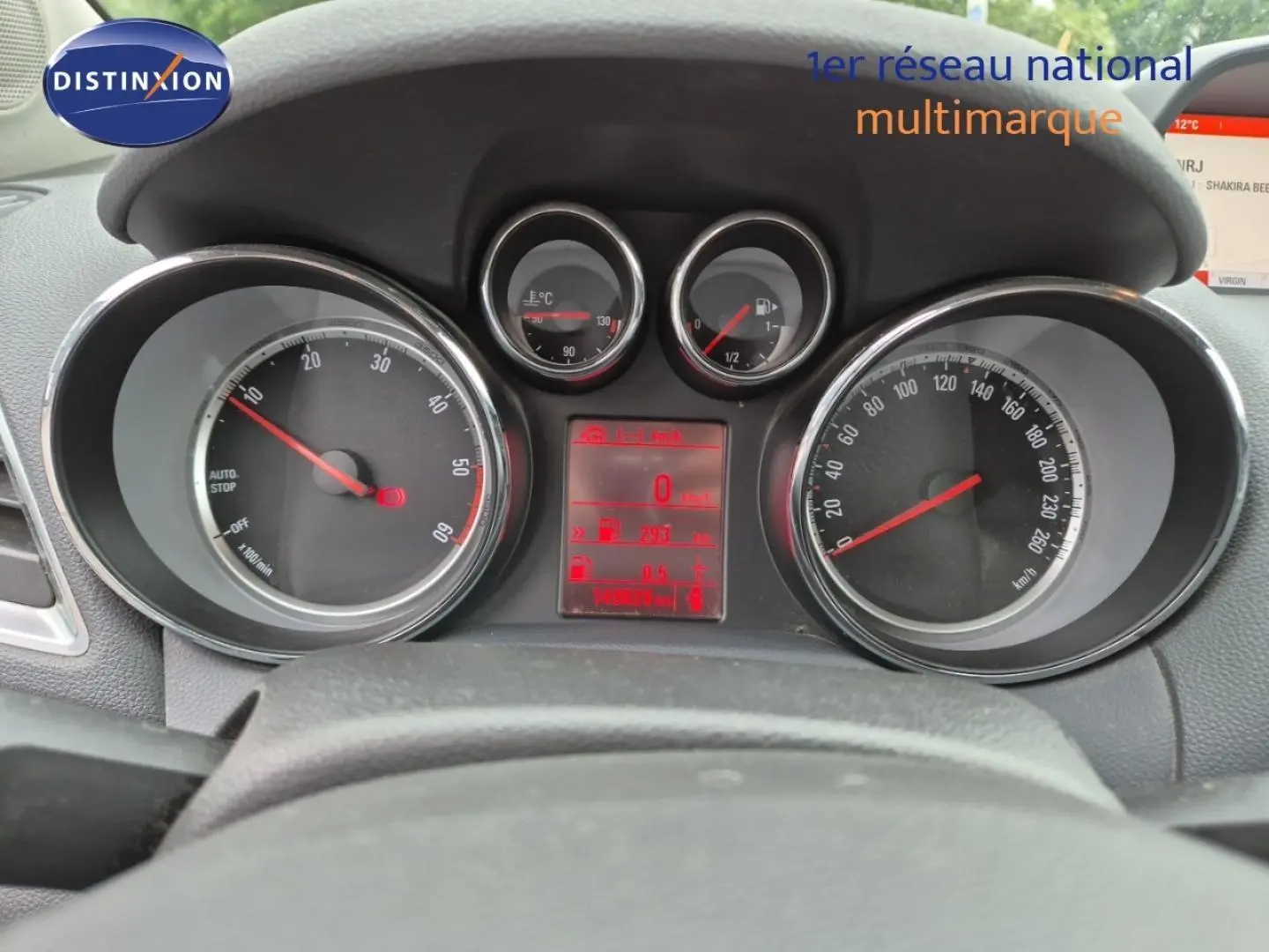 Vue rapprochée du tableau de bord et compteurs d’un Opel Mokka bleu outremer, affichage digital rouge au centre.