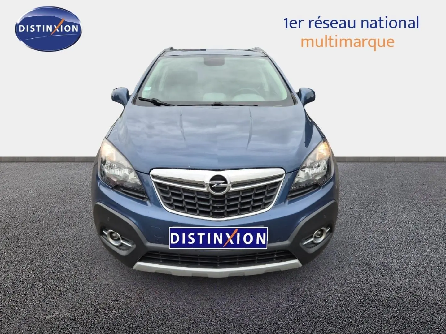Vue avant d'un Opel Mokka bleu outremer avec calandre chromée et phares allumés sur fond neutre.
