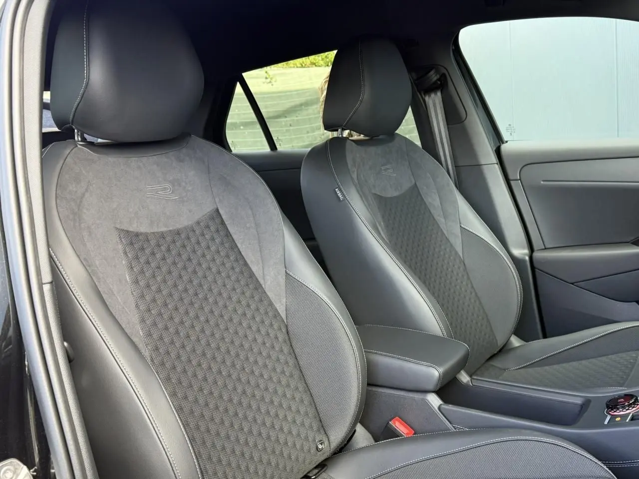 Vue intérieure montrant les sièges avant sport gris et noirs du Volkswagen T-Roc 2026 finition R-Line.