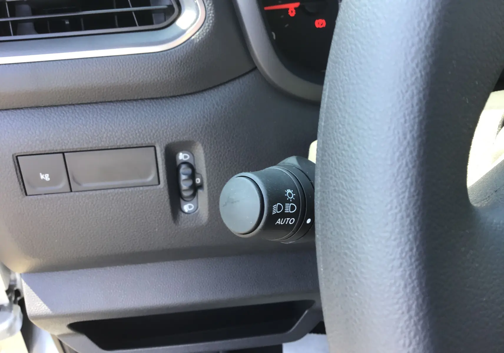 Détail du commodo d'éclairage à gauche du volant dans l'habitacle du Renault Master gris étoile 2024.