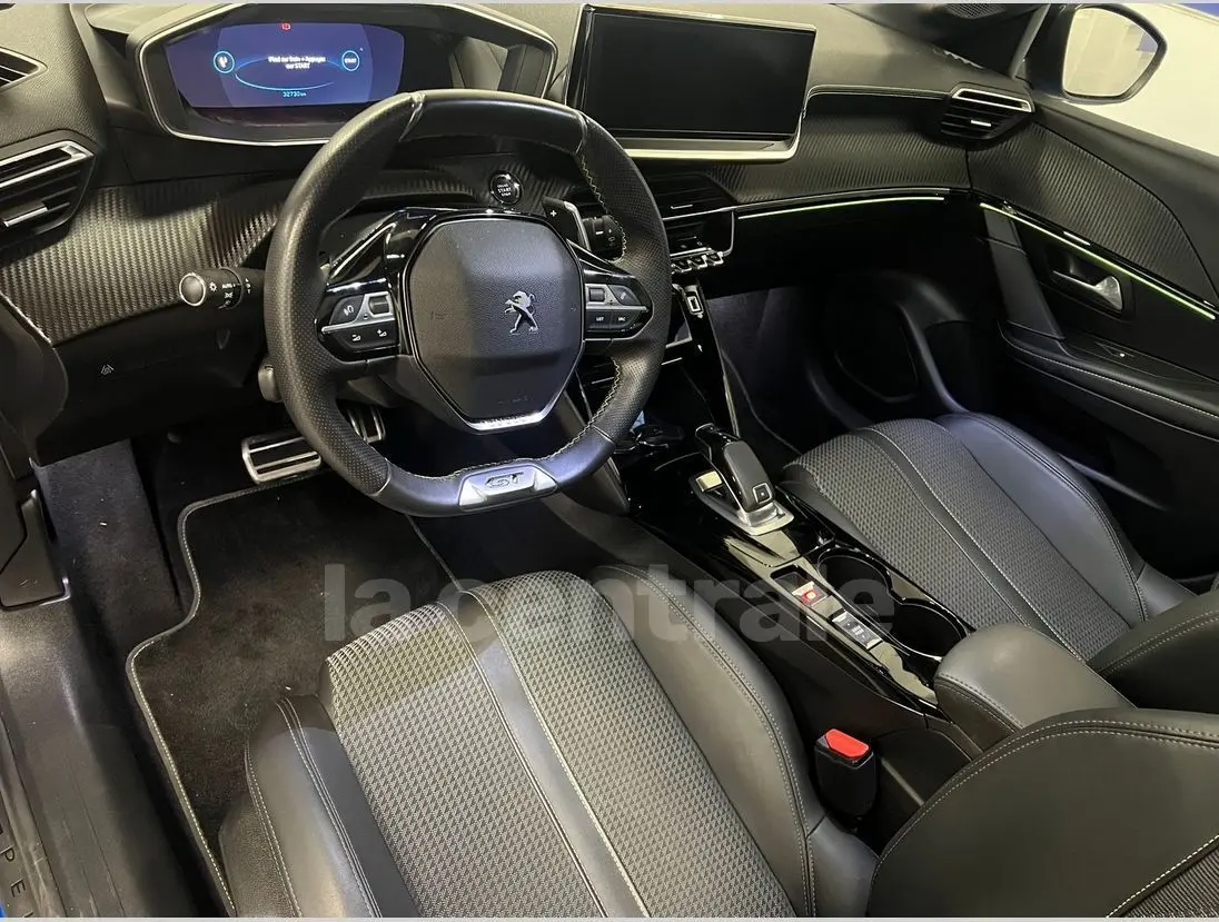 Intérieur de la Peugeot 208 GT Line 2020 vu côté conducteur, avec volant compact et éclairage d'ambiance vert.