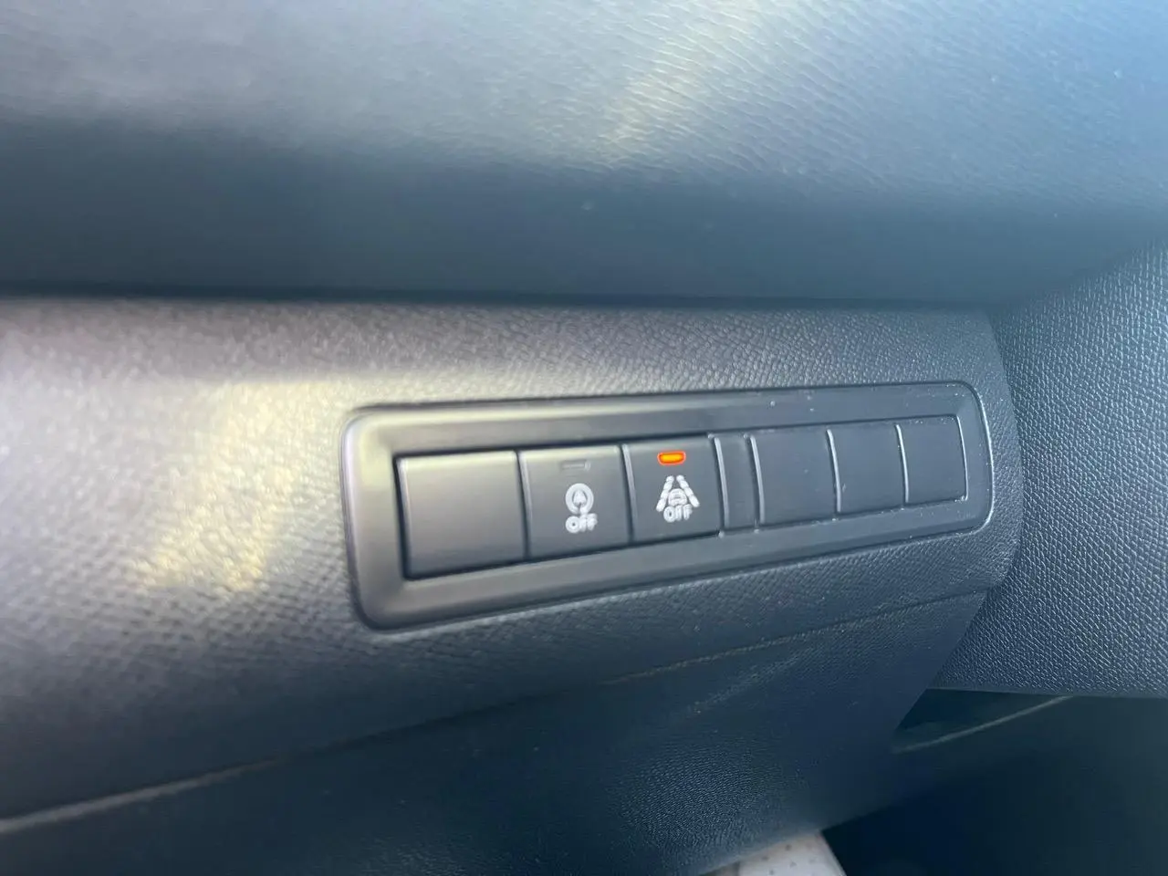 Boutons de commande d'assistance à la conduite sur tableau de bord noir d'une Peugeot 308 SW gris clair.