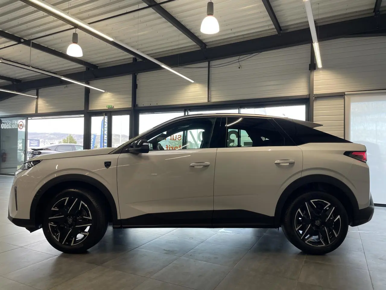 Vue de profil côté gauche du Peugeot 3008 blanc Okenite avec toit noir et jantes alliage 19'' diamantées.