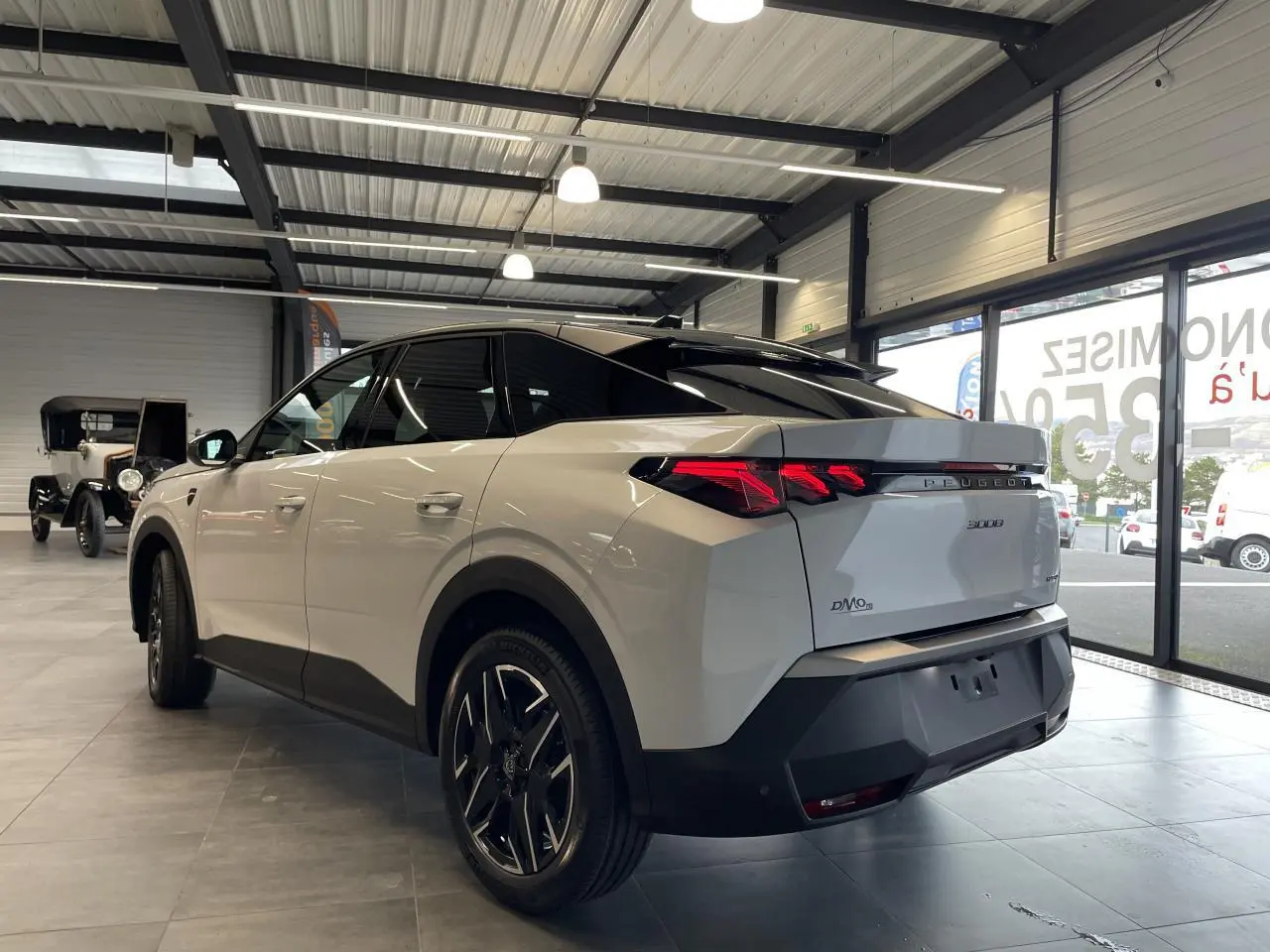 Vue 3/4 arrière droite du Peugeot 3008 blanc Okenite avec feux arrière à griffes LED et jantes alliage 19 pouces.