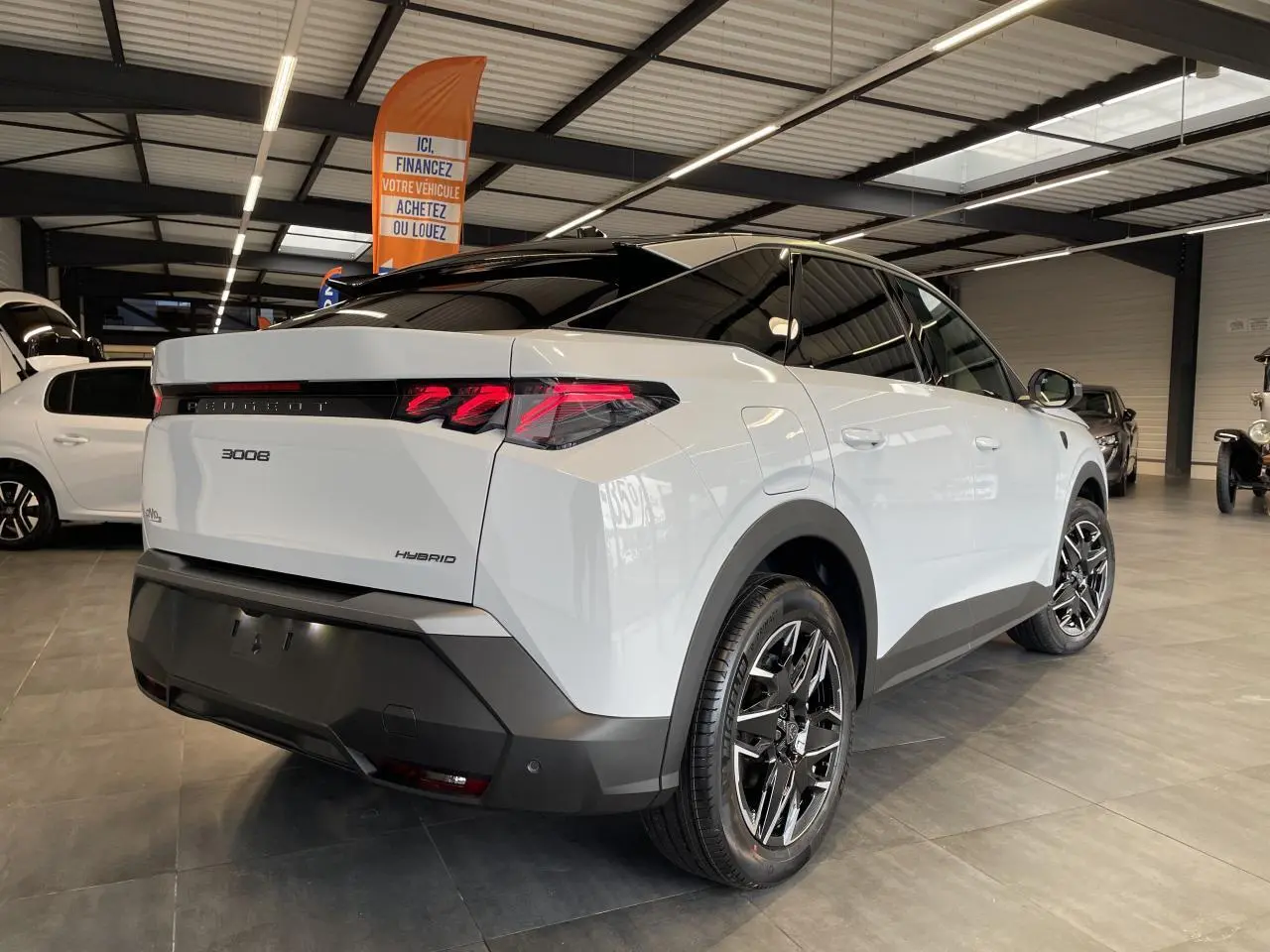 Vue 3/4 arrière droite d’un Peugeot 3008 blanc Okenite avec feux arrière à griffes LED et jantes alliage 19 pouces.