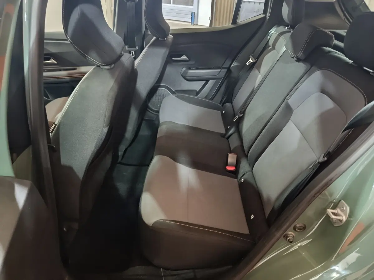 Vue intérieure côté droit montrant la banquette arrière grise et noire du Dacia Sandero Extreme+ TCe 110 vert 2024.
