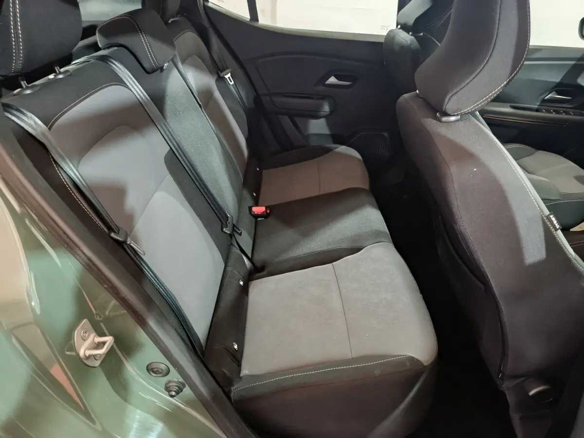 Vue intérieure côté gauche montrant la banquette arrière grise et noire du Dacia Sandero Extreme+ vert 2024.