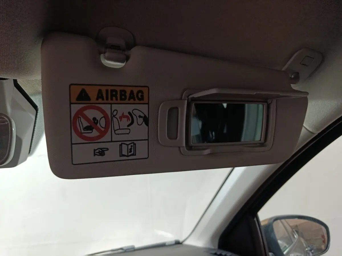Détail du pare-soleil côté conducteur avec miroir et avertissement airbag dans une Dacia Sandero 2024.