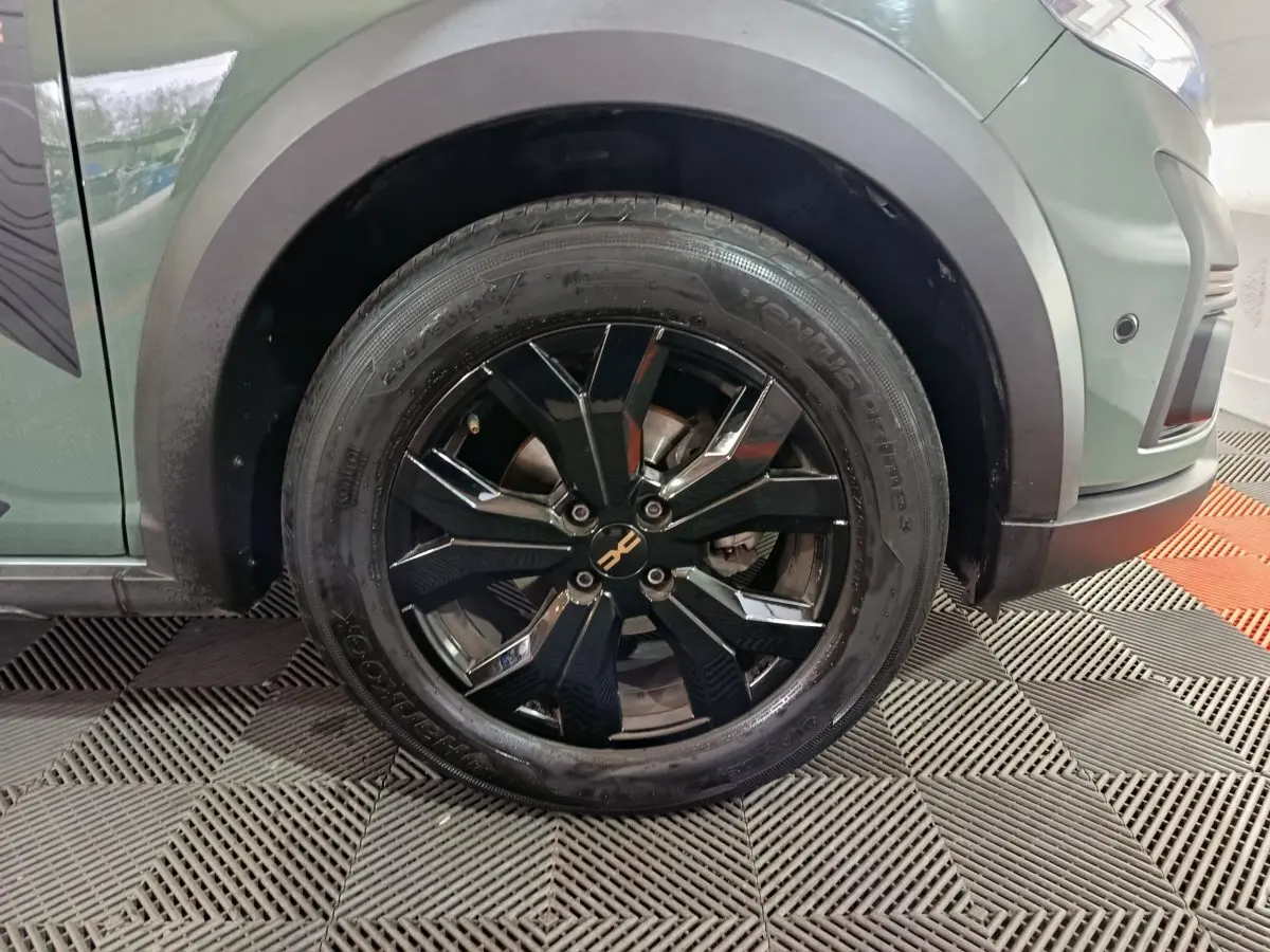 Gros plan sur la roue avant gauche noire à jante alliage du Dacia Sandero Extreme+ vert 2024.
