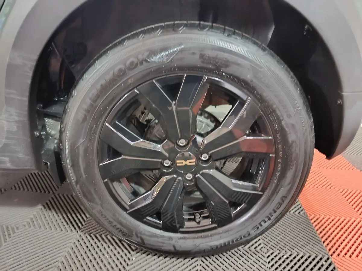 Gros plan sur la roue avant droite noire brillante de la Dacia Sandero Extreme+ TCe 110 verte de 2024.