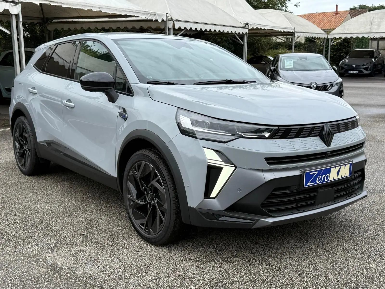 Renault Symbioz gris Rafale en vue 3/4 avant droit, avec calandre noire et jantes noires distinctives.