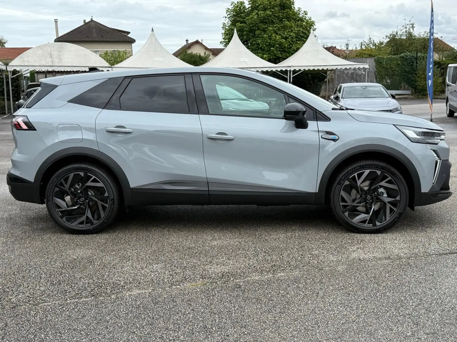 Vue de profil côté gauche du Renault Symbioz gris rafale 2026 avec jantes noires et lignes épurées.