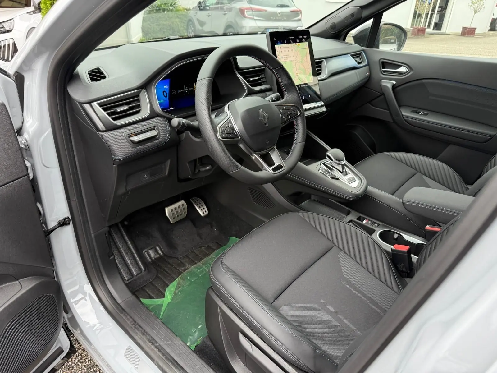 Vue intérieure côté conducteur de la Renault Symbioz 2026, avec tableau de bord numérique et écran tactile vertical.