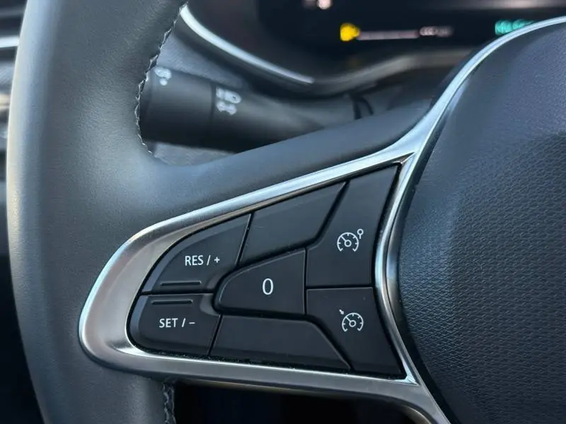 Gros plan sur les commandes de régulateur de vitesse à gauche du volant de la Renault Clio 2025, finition Techno.