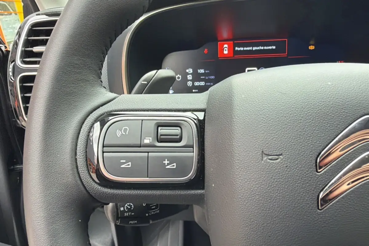 Gros plan sur le volant cuir multifonctions du Citroën C5 Aircross 2025, affichage digital et commandes intégrées visibles.