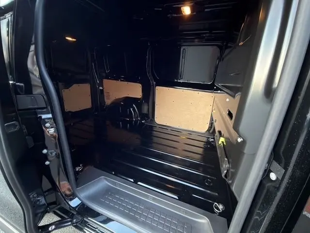 Vue intérieure arrière du Citroën Jumpy noir 2026 montrant l’espace de chargement avec cloison vitrée pleine.