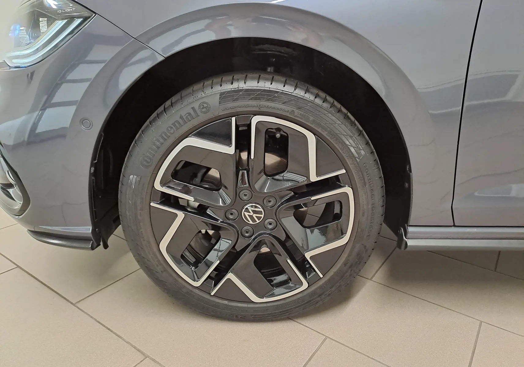 Gros plan sur la roue avant gauche d'une Volkswagen Polo 2025 gris cendré avec jante alliage R-Line noire et argent.