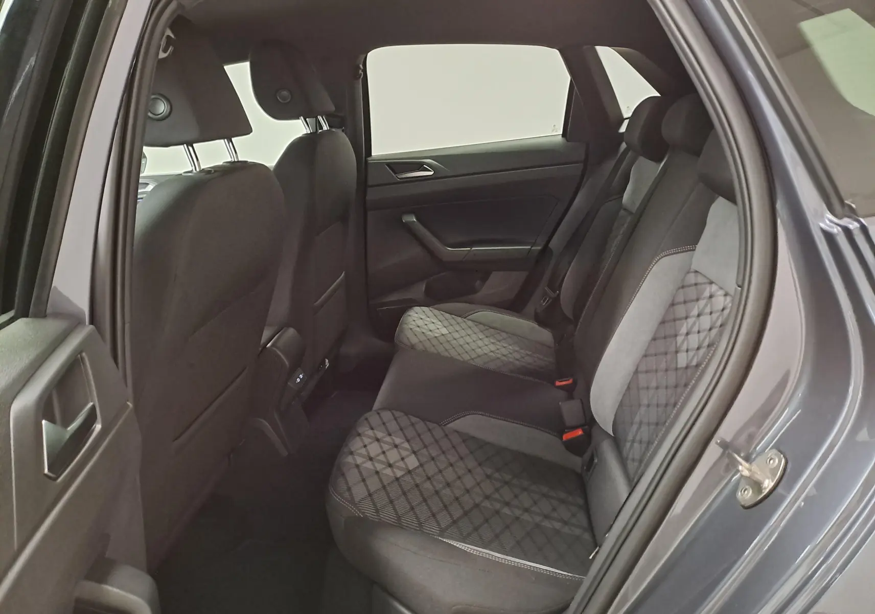 Vue intérieure arrière côté droit de la Volkswagen Polo 2025 gris cendré, sièges arrière avec tissu à motif losange.