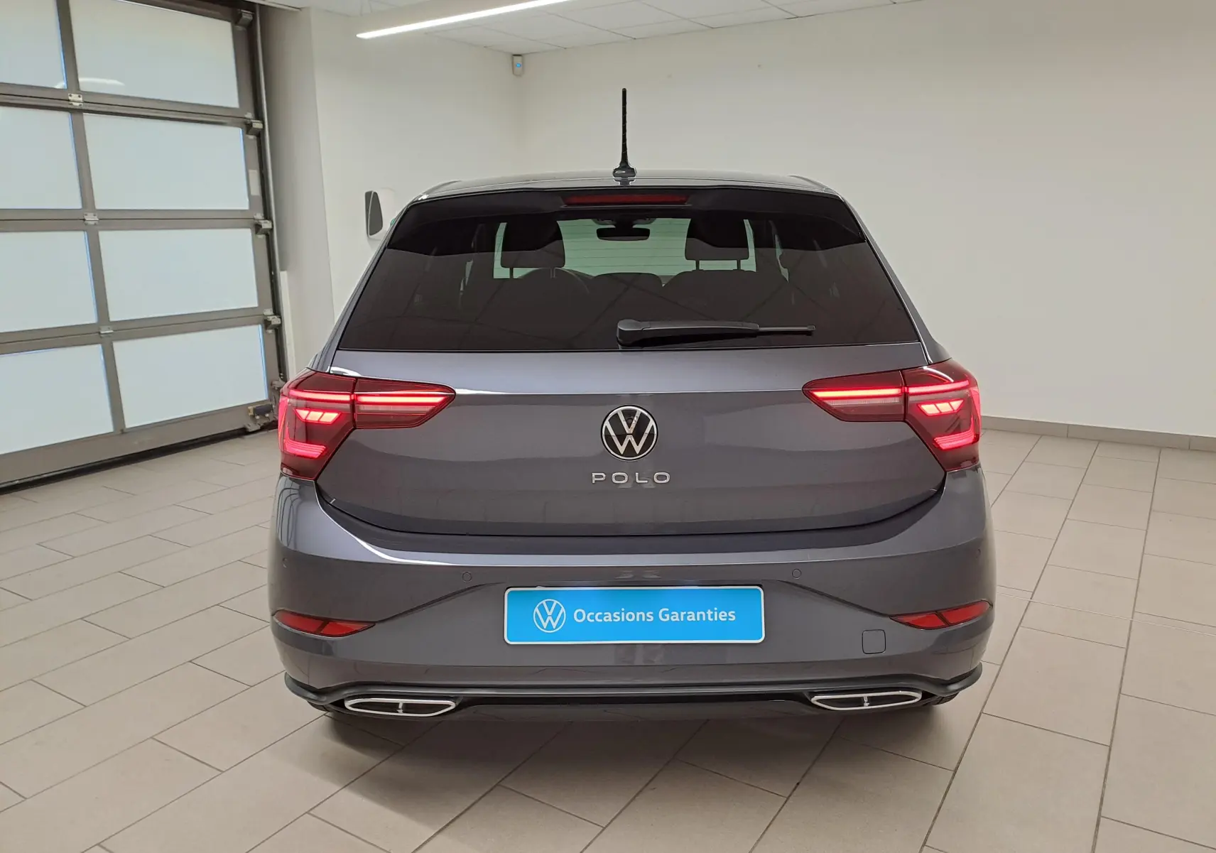 Vue arrière d'une Volkswagen Polo 2025 gris cendré métallisé avec feux LED et double sortie d'échappement intégrée.