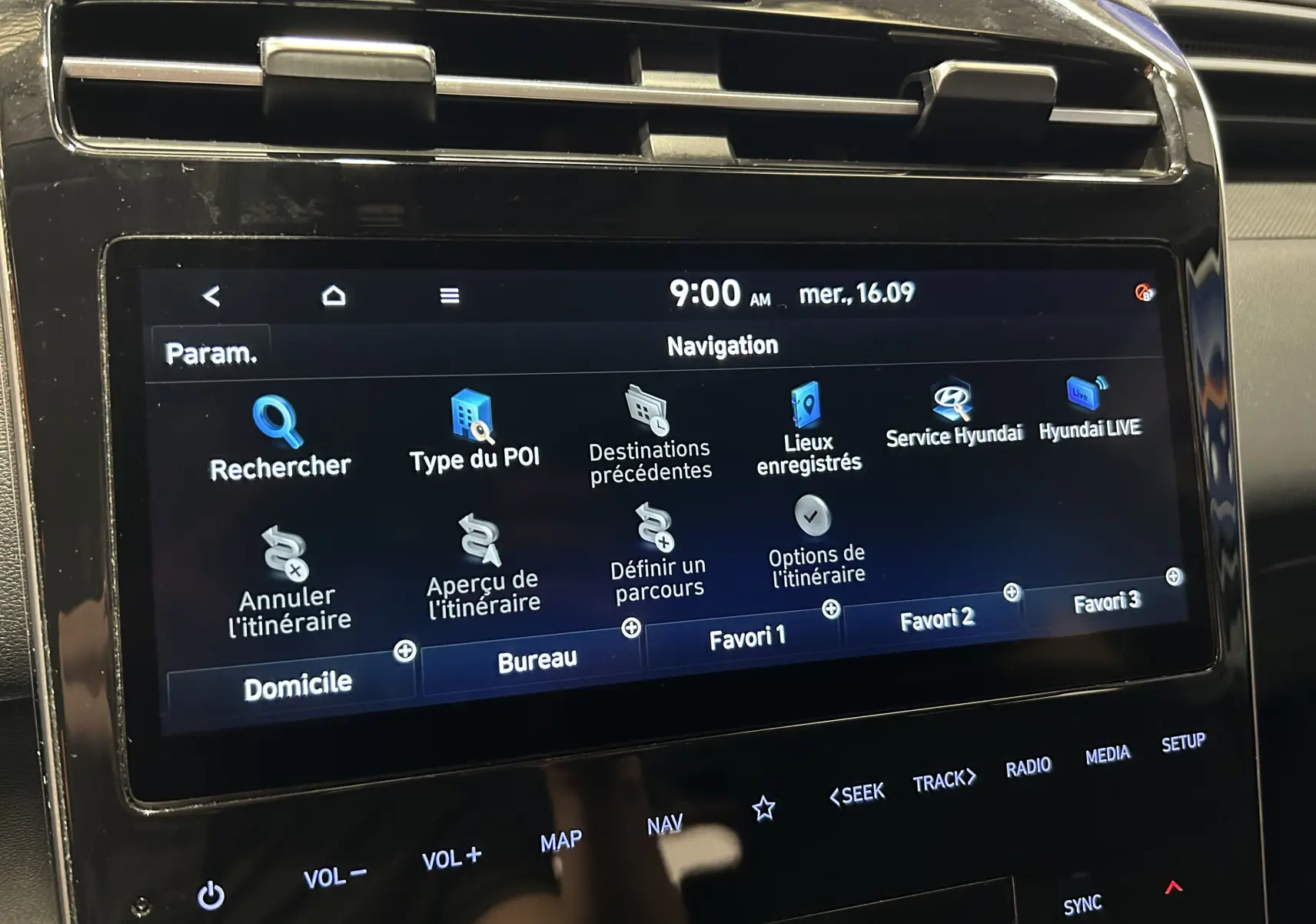 Écran tactile du système de navigation du Hyundai Tucson Hybrid 2022, affichant le menu principal en intérieur noir brillant.