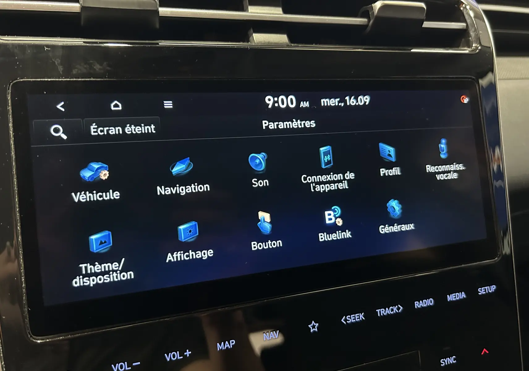 Écran tactile central du Hyundai Tucson Hybrid 2022 affichant le menu des paramètres en intérieur noir.