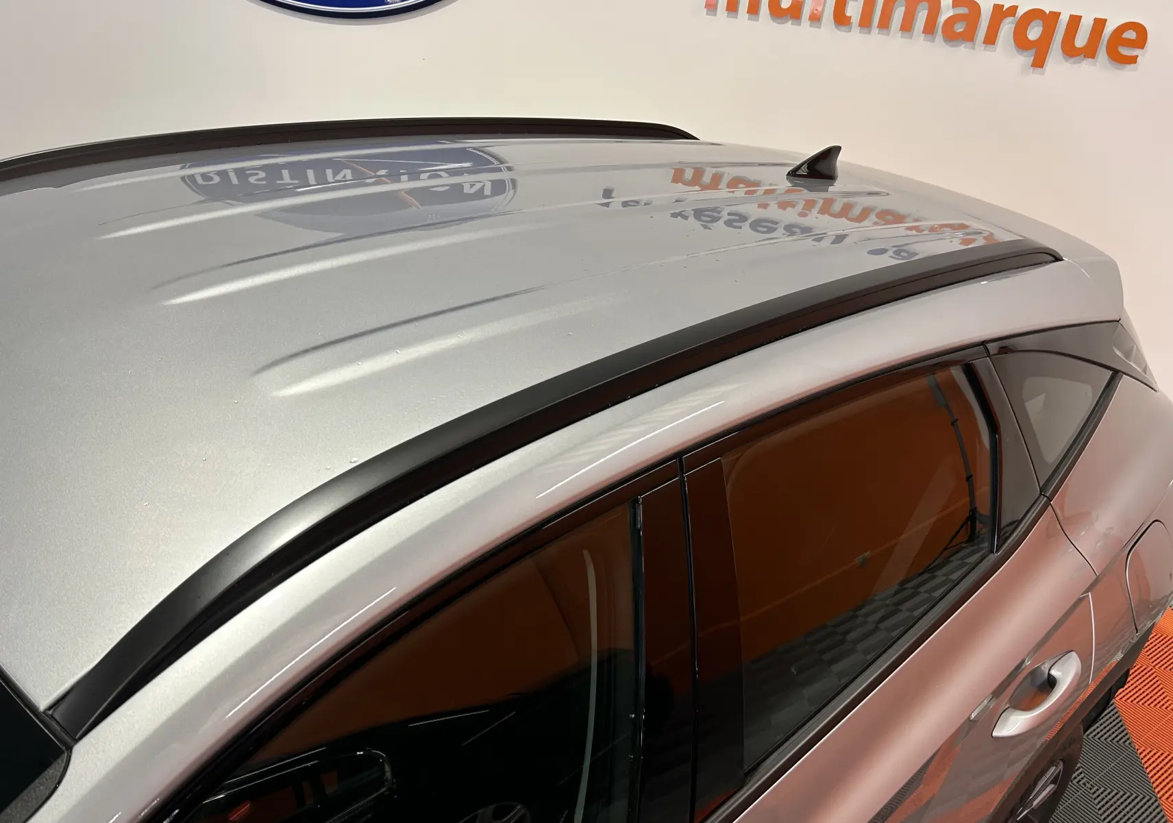 Vue en plongée du toit gris Shimmering Metal d'un Hyundai Tucson hybride 2022, avec barres de toit noires et antenne requin.