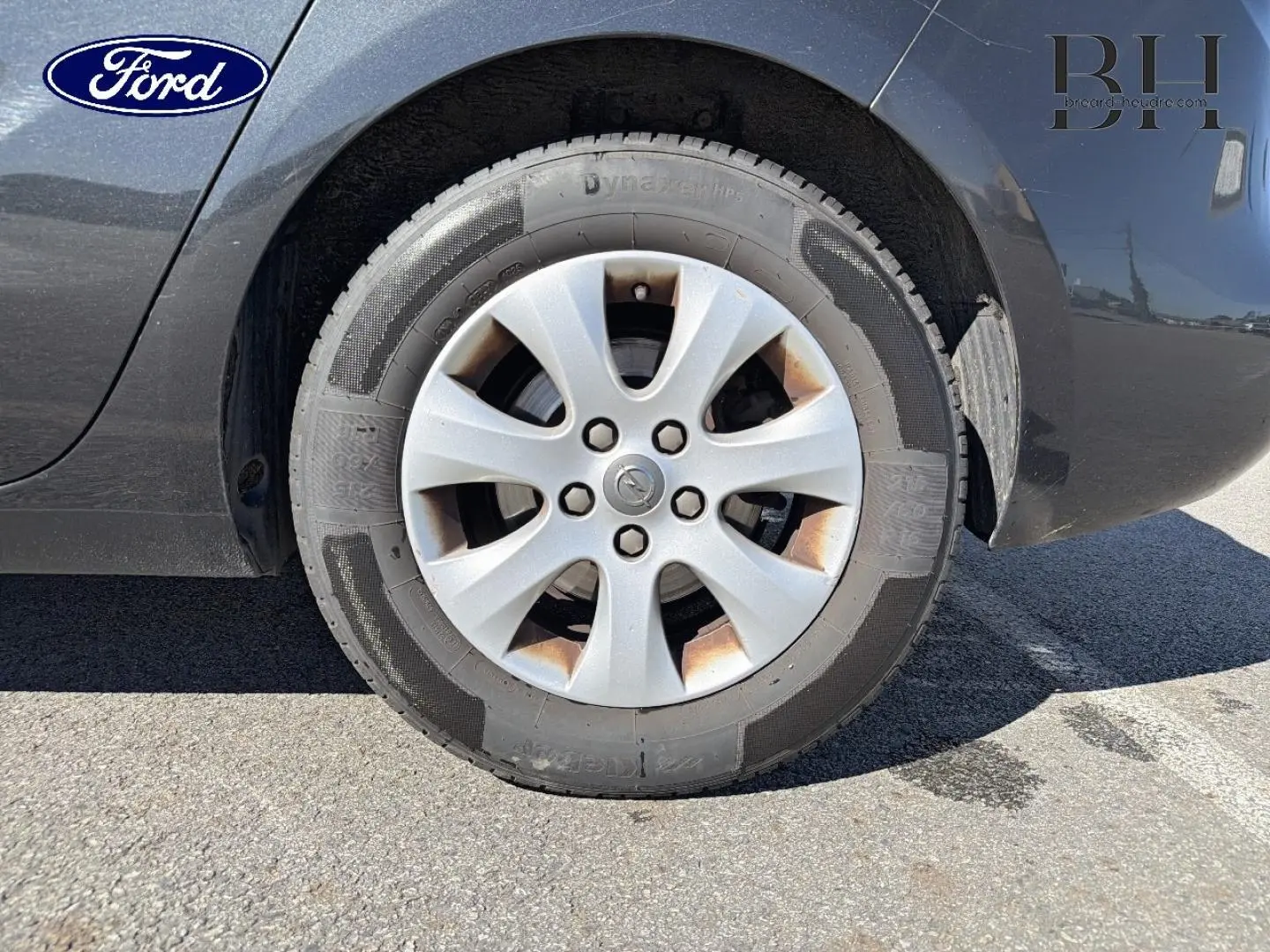 Gros plan sur la roue avant droite grise métallisée d’un Opel Zafira Tourer 2013 avec jante en alliage.