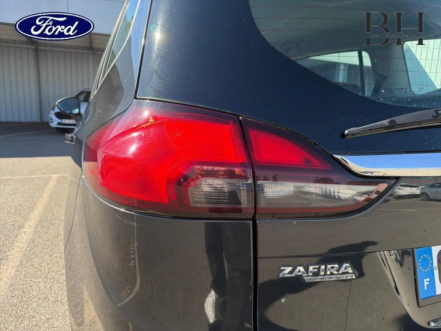 Gros plan sur l'arrière droit gris métal de l'Opel Zafira Tourer avec feu arrière et logo Zafira visible.