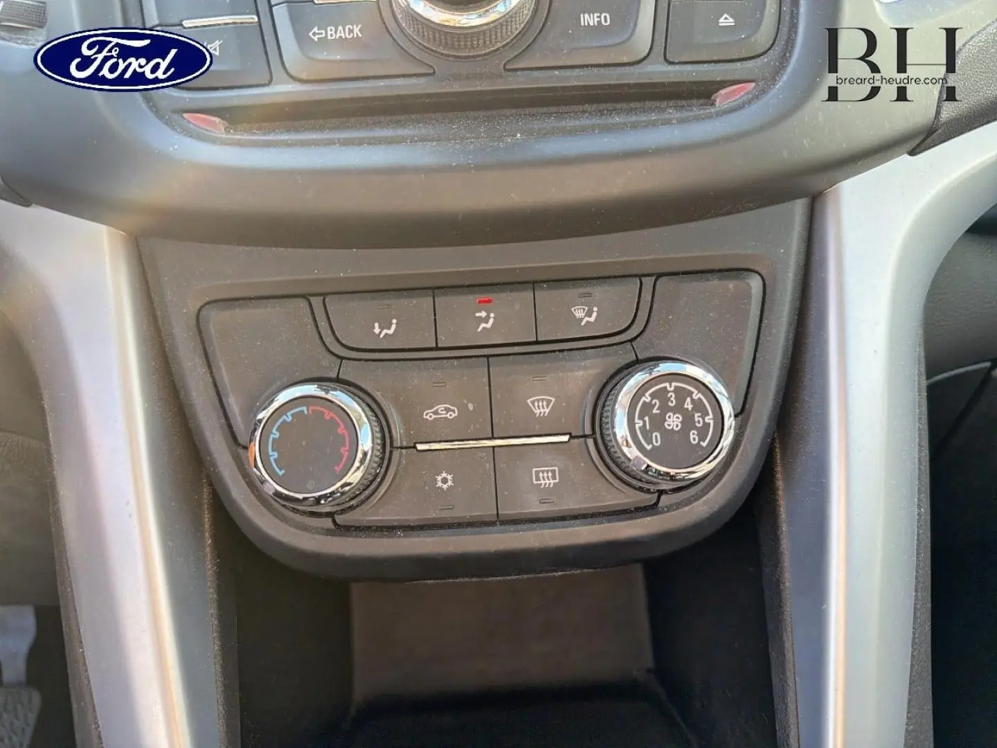 Détail du tableau de bord noir avec commandes de climatisation d'une Opel Zafira Tourer gris métal, vue frontale rapprochée.