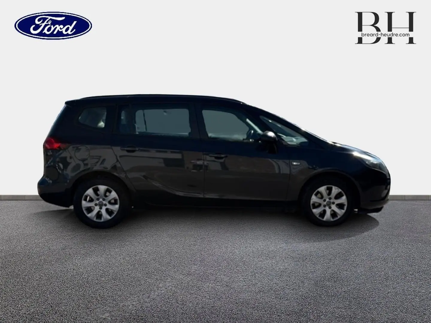 Vue de profil côté gauche d’un Opel Zafira Tourer gris métal, monospace compact avec vitres teintées et jantes alliage.