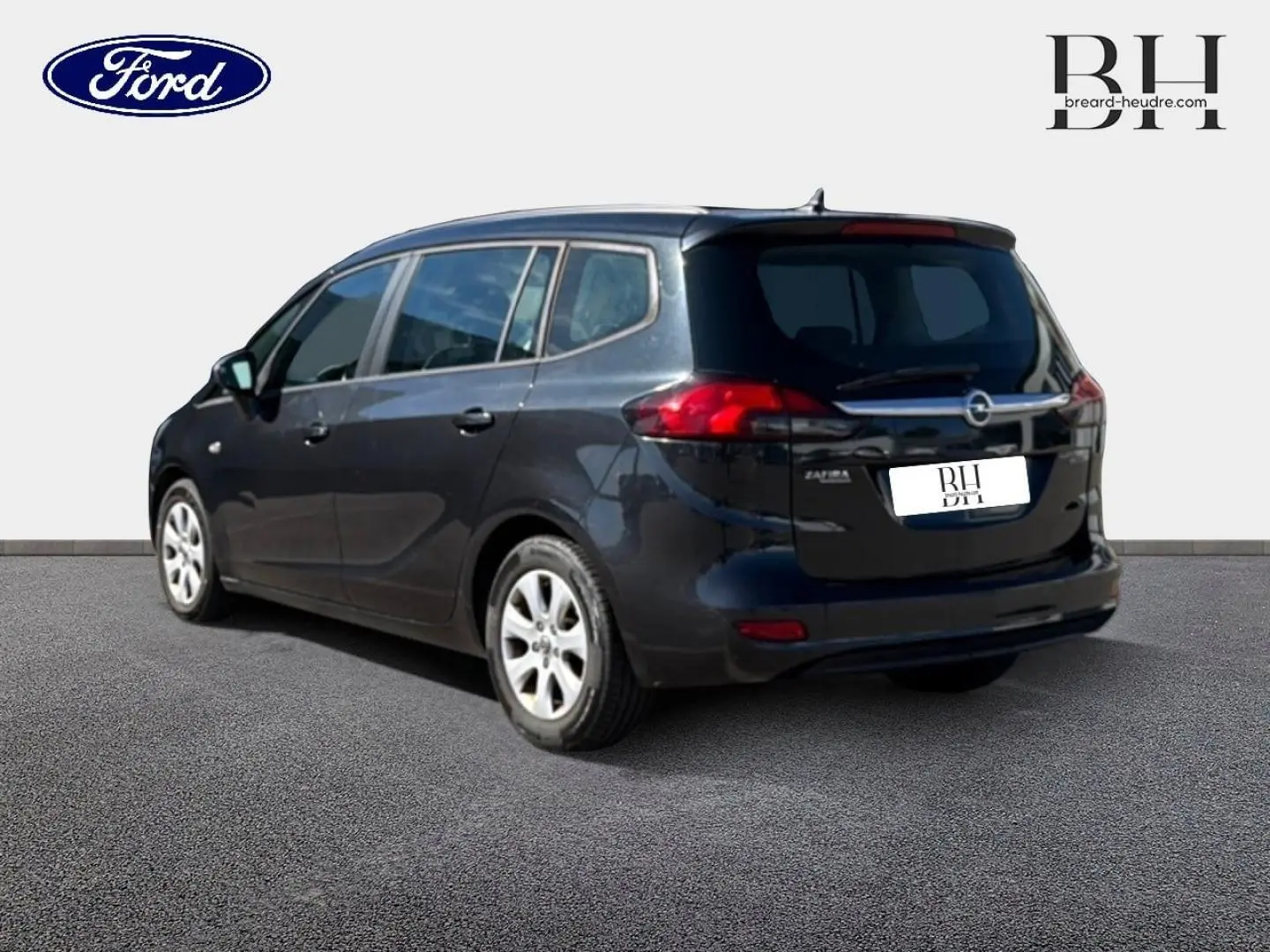 Opel Zafira Tourer gris métal vue 3/4 arrière droit, avec feux arrière rouges et vitres teintées.