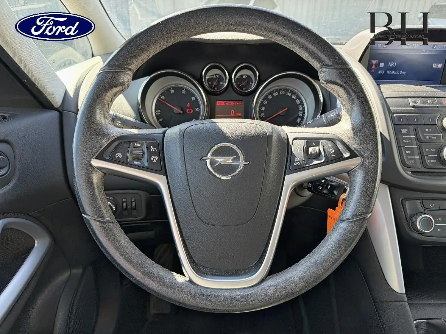 Vue intérieure centrée sur le volant cuir d'une Opel Zafira Tourer 2013 avec tableau de bord et commandes visibles.