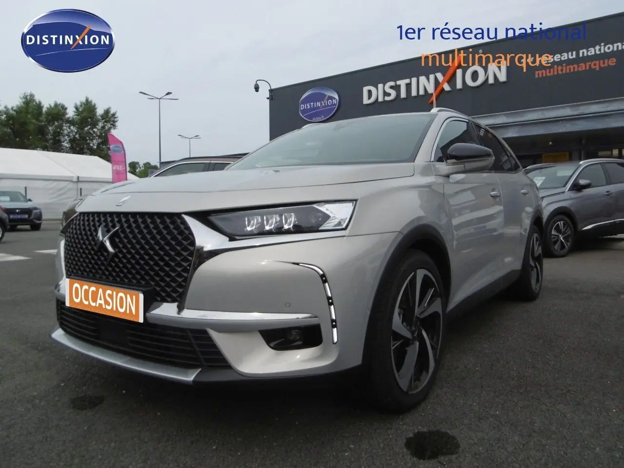 DS7 Crossback hybride rechargeable Crystal Pearl en 3/4 avant droit, avec calandre noire distinctive et jantes stylées.