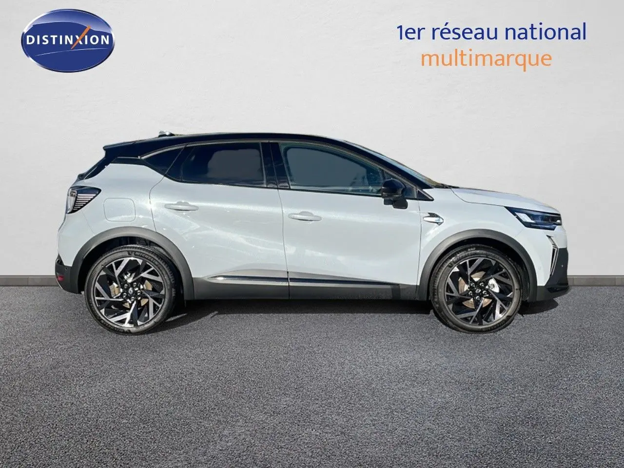 Profil côté droit du Renault Captur E-Tech hybride 2025 gris rafale métal avec toit noir et jantes noires distinctives.