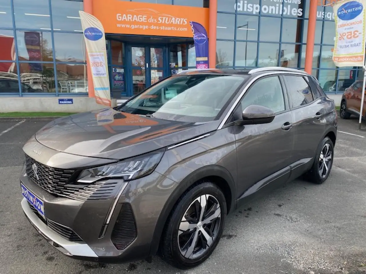 Peugeot 3008 gris platinium en 3/4 avant droit, avec jantes alliage bi-ton et toit ouvrant panoramique visible.