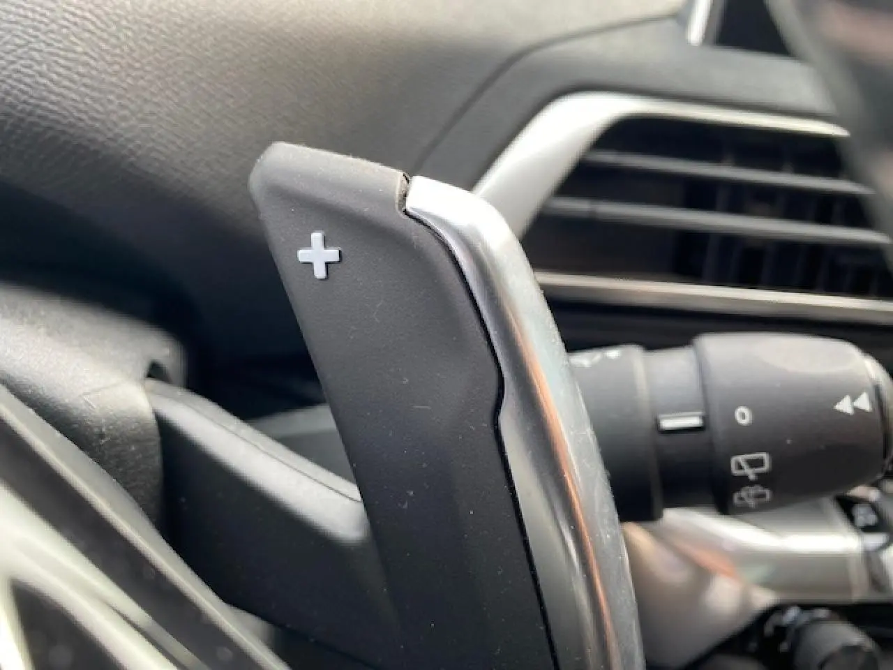 Gros plan sur la palette de changement de vitesse "+" côté droit du volant du Peugeot 3008 gris platinium.