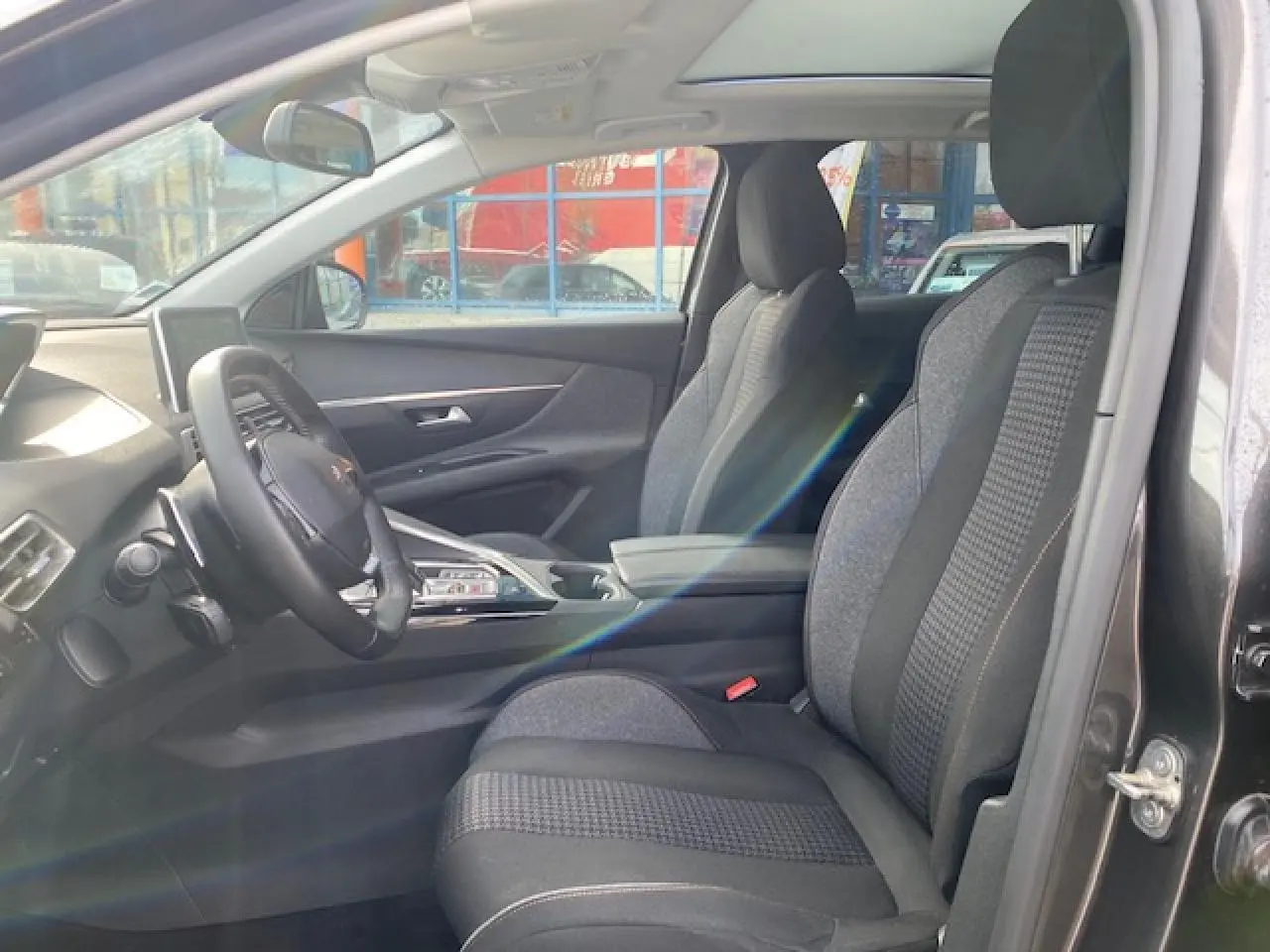 Intérieur du Peugeot 3008 gris platinium, vue côté gauche sur les sièges avant et le tableau de bord moderne.