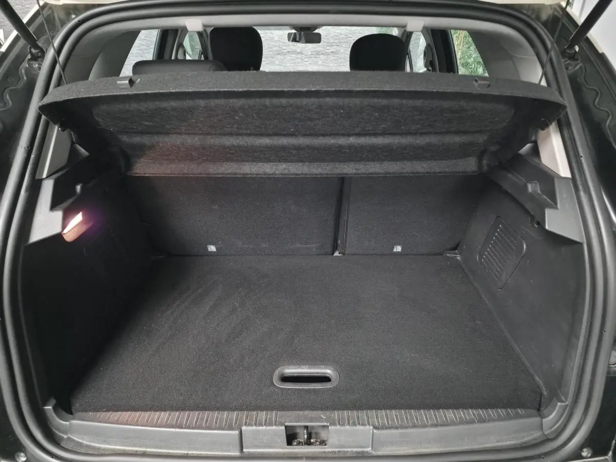 Coffre ouvert du Renault Captur noir 2014, vue arrière montrant le plancher plat et la tablette cache-bagages relevée.