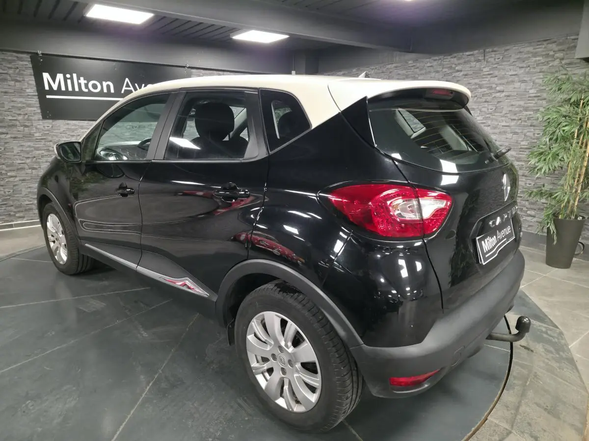 Renault Captur noir vue 3/4 arrière droit avec attelage et jantes alliage 16 pouces dans showroom.