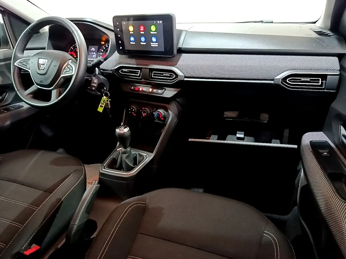 Vue intérieure avant droite du tableau de bord et volant cuir synthétique de la Dacia Sandero Confort TCe 90 2022.