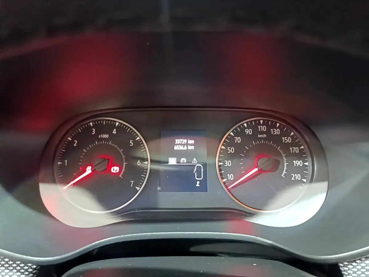 Vue rapprochée du tableau de bord du Dacia Sandero blanc 2022, affichant compte-tours, vitesse et écran multifonctions.