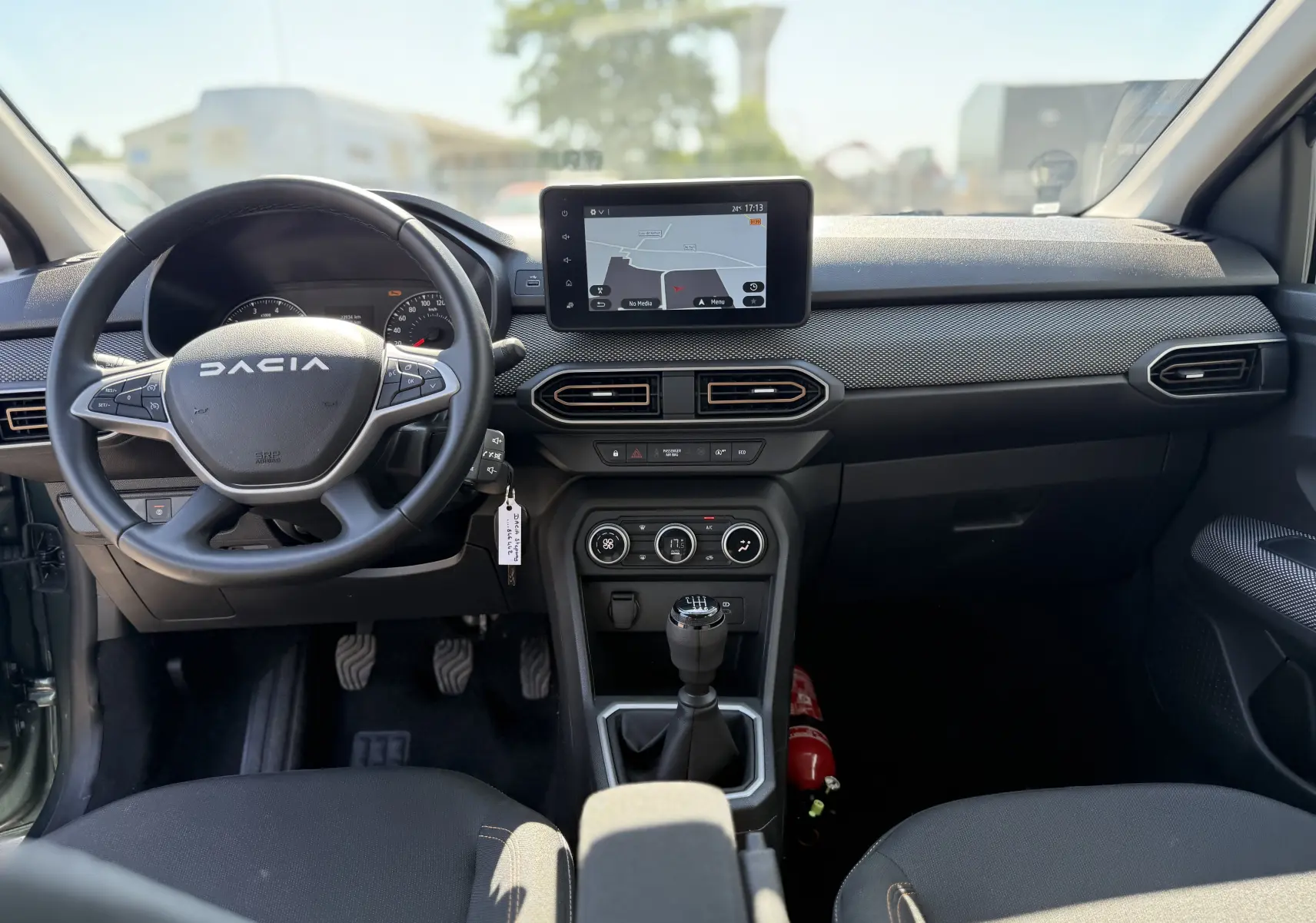 Vue intérieure avant du tableau de bord de la Dacia Sandero Stepway 2025 avec volant multifonction et écran tactile central.
