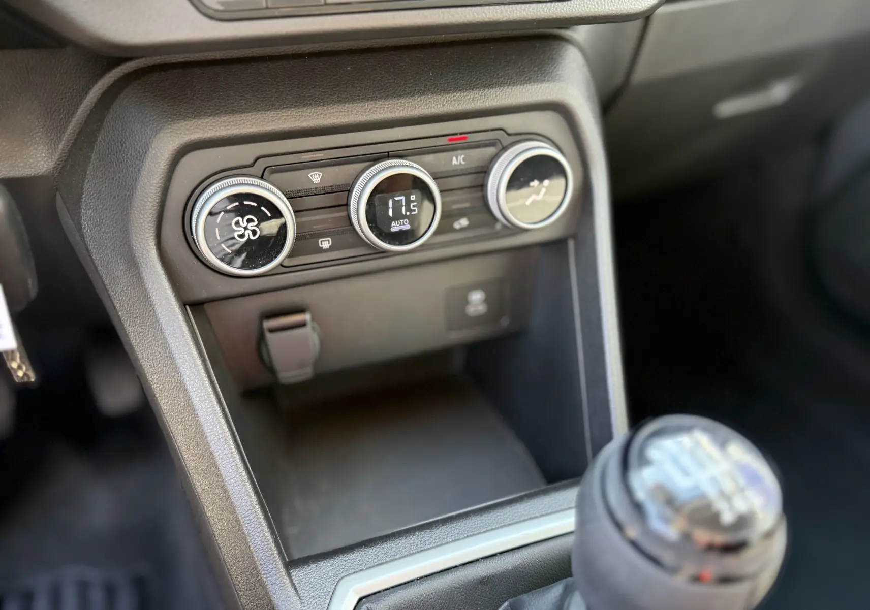 Gros plan sur la console centrale et la commande de climatisation de la Dacia Sandero Stepway TCE 90, intérieur noir.