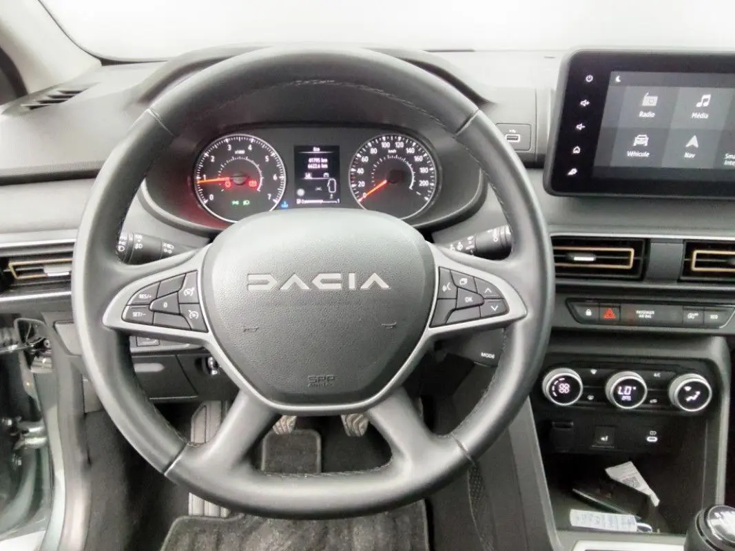 Vue centrée sur le volant DACIA d’une Sandero Stepway 2025, avec tableau de bord et écran tactile visibles.