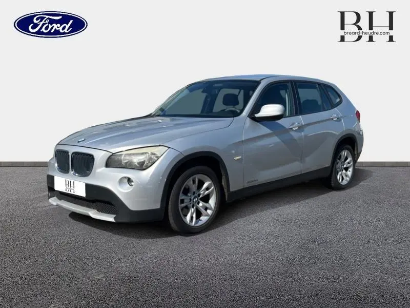 BMW X1 gris métallisé vue 3/4 avant droit, avec jantes alu 17 pouces et calandre caractéristique double haricot.