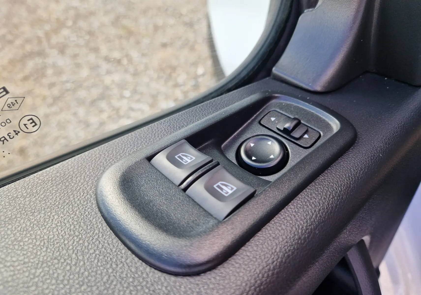 Gros plan sur les commandes électriques des vitres et des rétroviseurs côté conducteur du Renault Master blanc 2024.