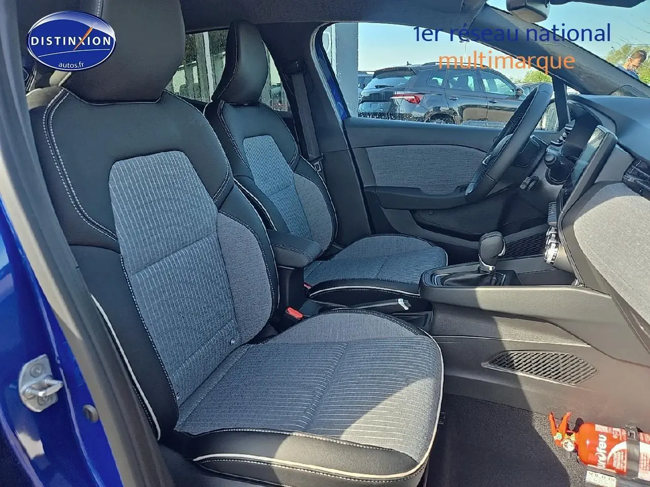 Intérieur de la Renault Clio V 1.6 e-tech 145 techno bleu iron, vue côté gauche sur les sièges avant sport et console centrale.