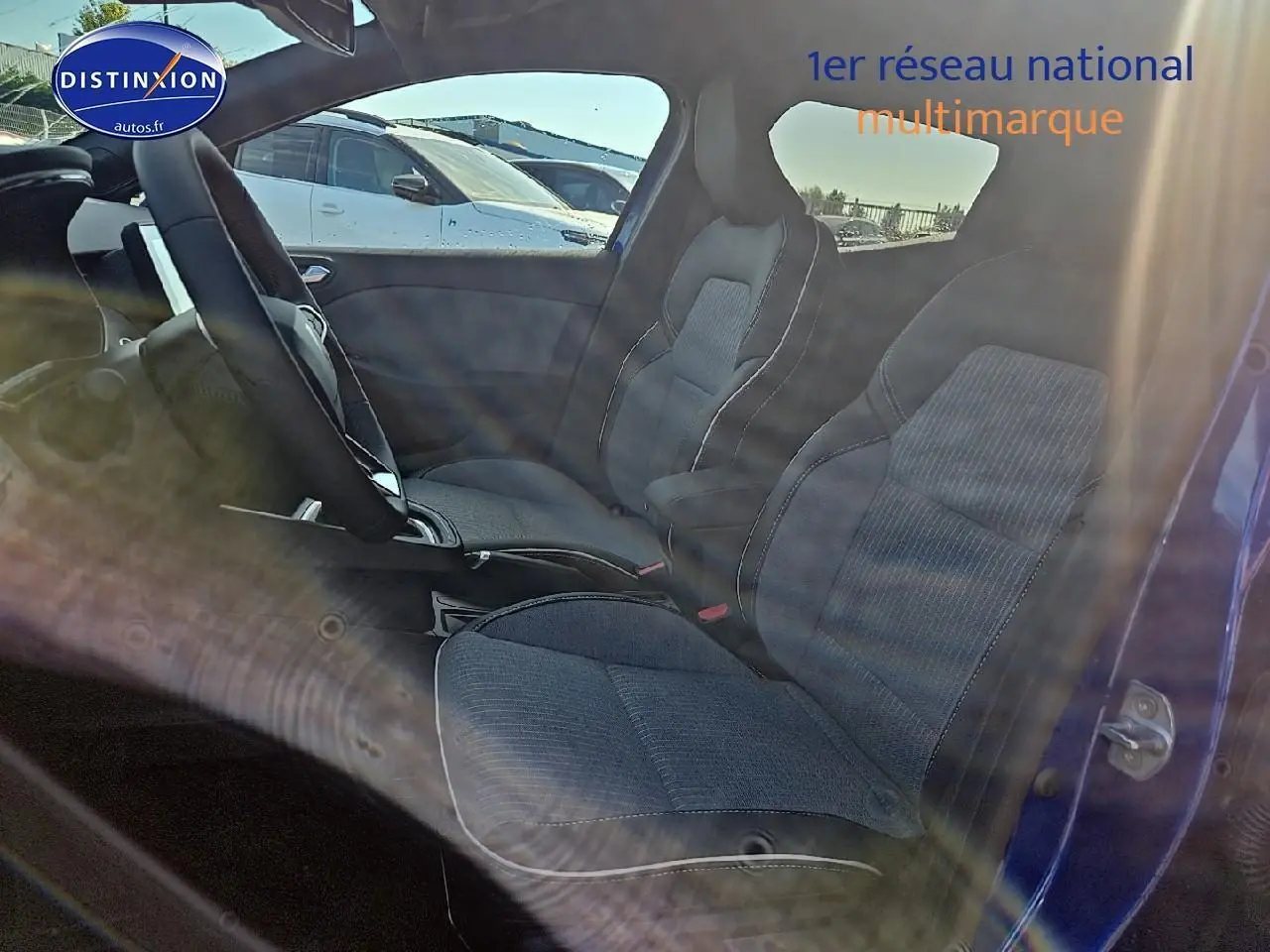 Intérieur de la Renault Clio V 1.6 e-tech 145 techno, sièges sport gris et bleu iron visible côté gauche ouvert.