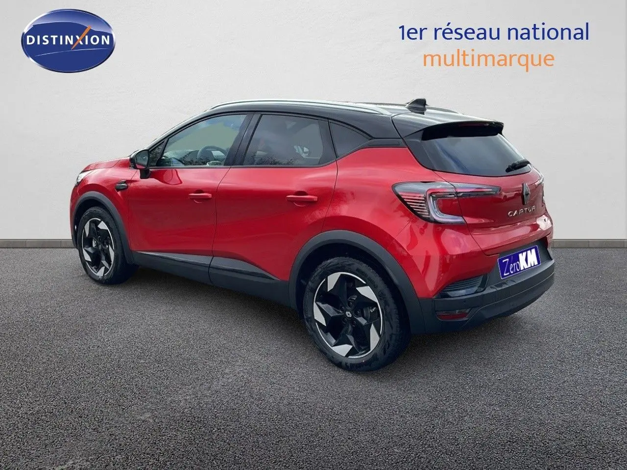 Vue 3/4 arrière droite d'un Renault Captur E-Tech hybride rouge passion avec toit noir et jantes noires.